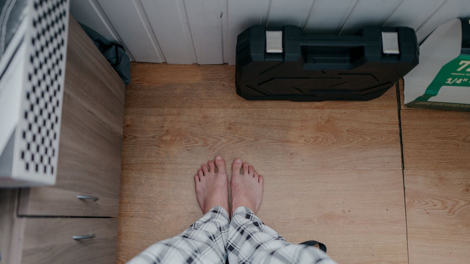 Pieds nus en pyjama posés sur un parquet clair, vus du dessus au réveil