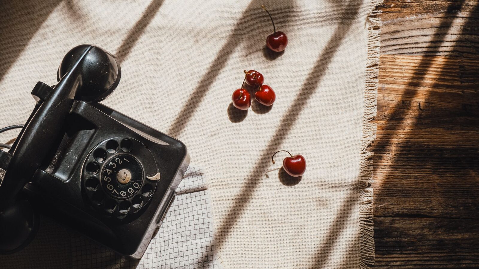 Téléphone à cadran posé sur une table en bois un matin d'hiver