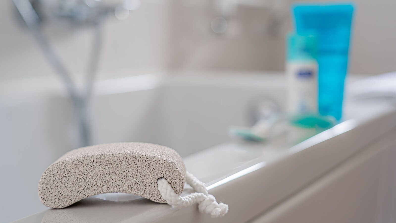 Pierre ponce posée sur le rebord d’une baignoire, près d’une serviette